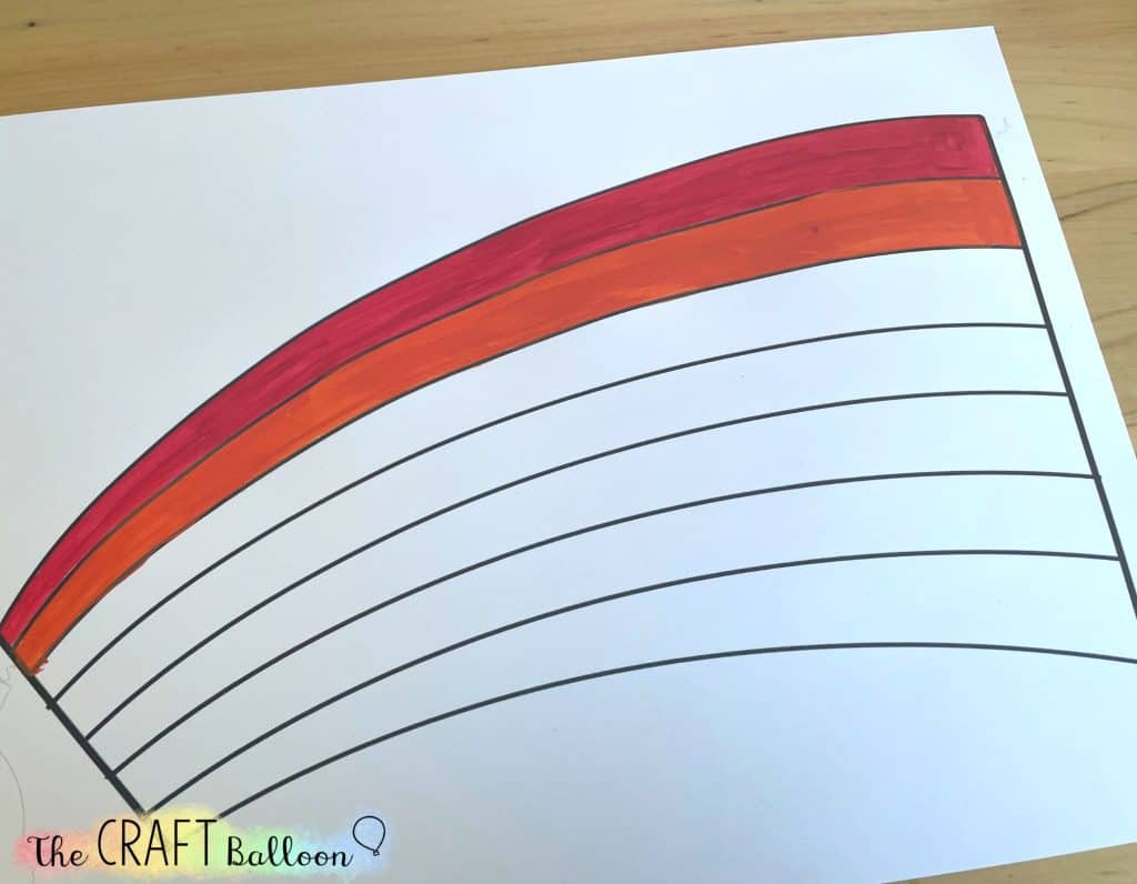 Printed rainbow template with red and orange stripes already painted.