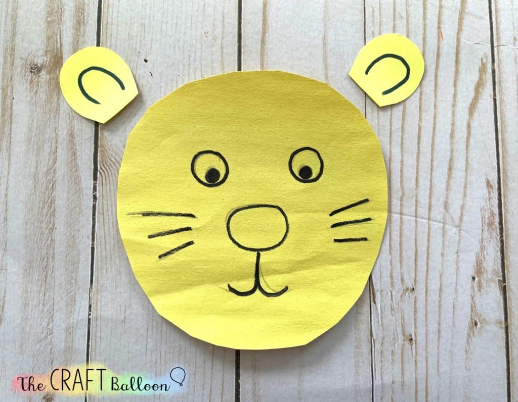 simple lion face and two ears on yellow paper